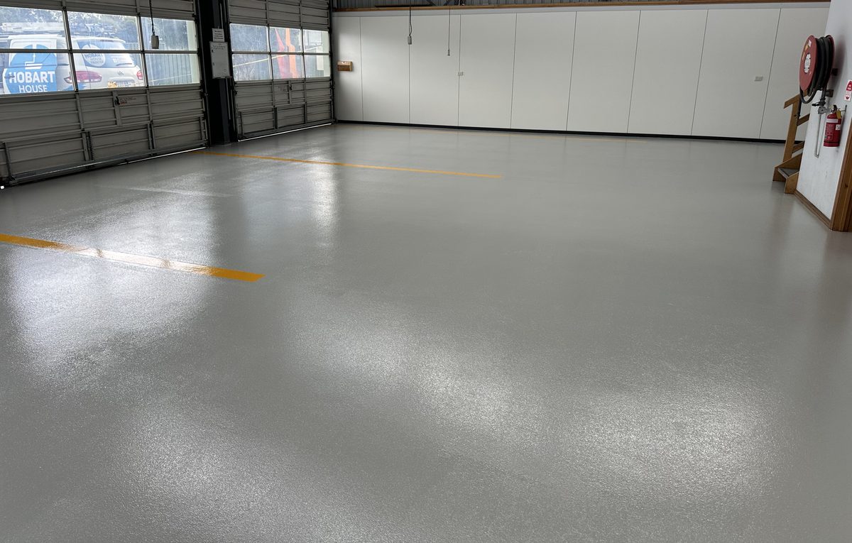 Finished glossy grey epoxy warehouse floor with yellow line-marking